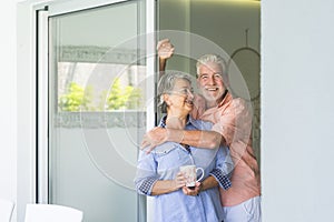 Happy senior people at home in retired lifestyle - active seniors smile and hug with love and relationship - indoor leisure