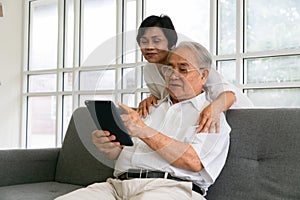 Happy senior people using digital tablet as a learning tool and spending time together, Asian Senior friends  at home
