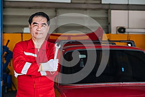 Happy senior professional Asian male mechanic garage worker happy working replace maintenance car service in auto workshop