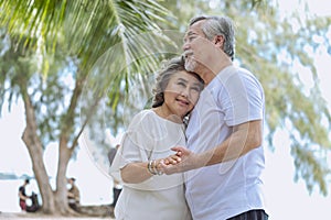 Happy senior retired couple, relax smiling elder man and woman enjoying with retired vacation at sea beach outdoor. Health