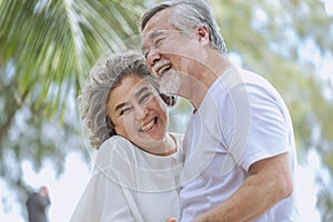 Happy senior retired couple, relax smiling elder man and woman enjoying with retired vacation at sea beach outdoor. Health