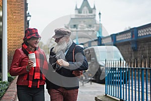 Happy senior retired couple walking outdoors by the city - Focus on faces