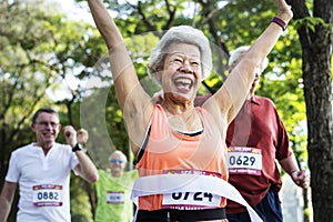 Happy senior running through the finish line