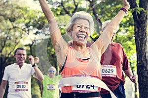 Happy senior running through the finish line