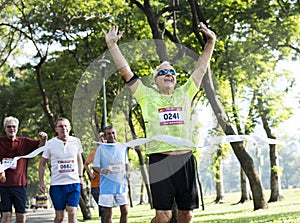 Happy senior running through the finish line