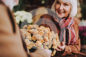 Happy senior woman accepting present from loving husband