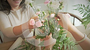 Happy senior woman arranging flowers in vase at her floral shop. Floristry, small business and people concept