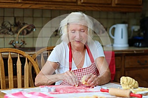 Happy senior woman baking cookies in the kitchen