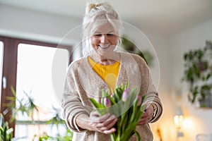 Happy senior woman with bouquet of tulips