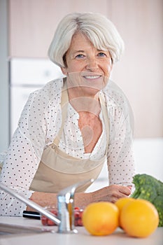 Happy senior woman cooking in modern kitchen