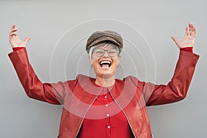 Happy senior woman dancing and laughing outdoor - Trendy mature person having fun during retired time