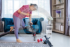 Happy senior woman doing exercise with dumbbells at home