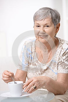 Happy senior woman drinking coffee