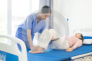 Happy senior woman exercising at home with muscle physiotherapist Retired elderly woman