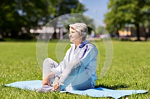 Happy senior woman exercising at summer park
