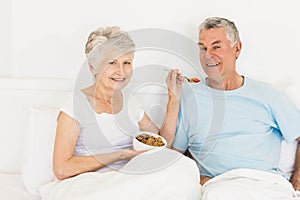 Happy senior woman feeding her husband