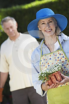 Happy Senior Woman Holding Flower Pot