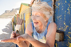 Happy senior woman holding meltid ice cream