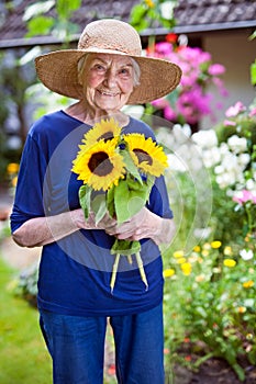 Happy Senior Woman Holding Pretty Sunflowers