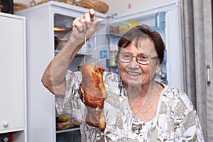 Happy senior woman holding smoked meat