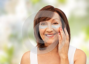 Happy senior woman with hydrogel under-eye patches