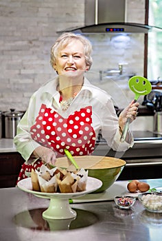 Happy senior woman baking in a bright modern kitchen