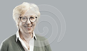 Happy senior woman posing on gray background