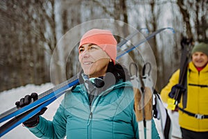 Happy senior woman preparing for winter skiing with her husband.