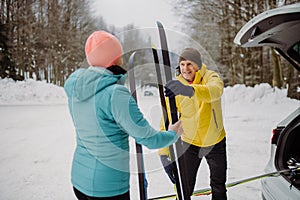 Happy senior woman preparing for winter skiing with her husband.