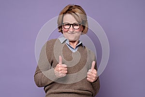 An happy senior woman showing her two thumbs up