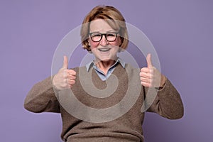 An happy senior woman showing her two thumbs up