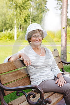 Happy senior woman sitting on a bench