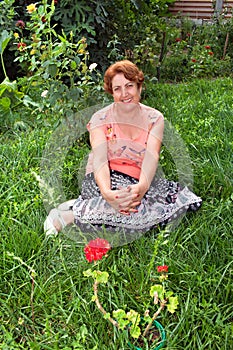 Happy Senior Woman Sitting In The Grass