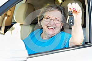 Happy Senior Woman Sitting In New Car Holding The Keys