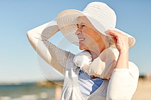 Happy senior woman in sun hat on summer beach