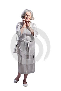 Happy senior woman wearing light dress posing isolated