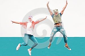 Happy seniors crazy couple wearing unicorn and t-rex mask while jumping outdoor - Mature trendy people having fun celebrating