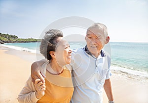 Happy seniors walking on the beach