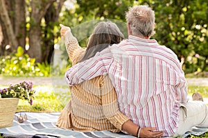 Happy senor european man and lady sit on plaid, enjoy romantic date, picnic photo