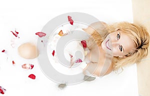 Happy Sensual Alluring Caucasian Blond in Foamy Bathtub Filled with Rose Petal