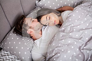Happy sensual young couple lying in bed together.