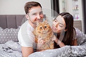 Happy sensual young couple lying in bed together.