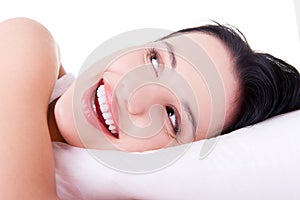 Happy sensual young woman lying in bed