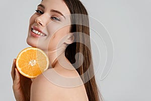 Happy shirtless nice girl smiling while posing wit orange