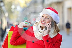 Happy shopper talking on phone on christmas photo