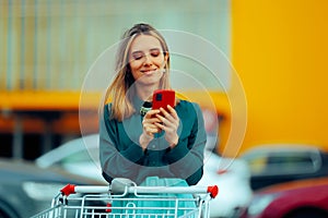 Happy with Shopping Cart Checking her Phone Before Entering Store