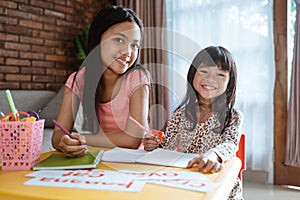 Happy sibling studying together at home