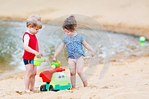 Happy siblings: boy and girl playing together in summer
