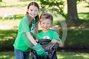 Happy siblings collecting rubbish