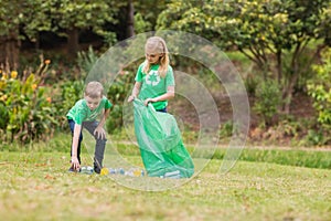 Happy siblings collecting rubbish